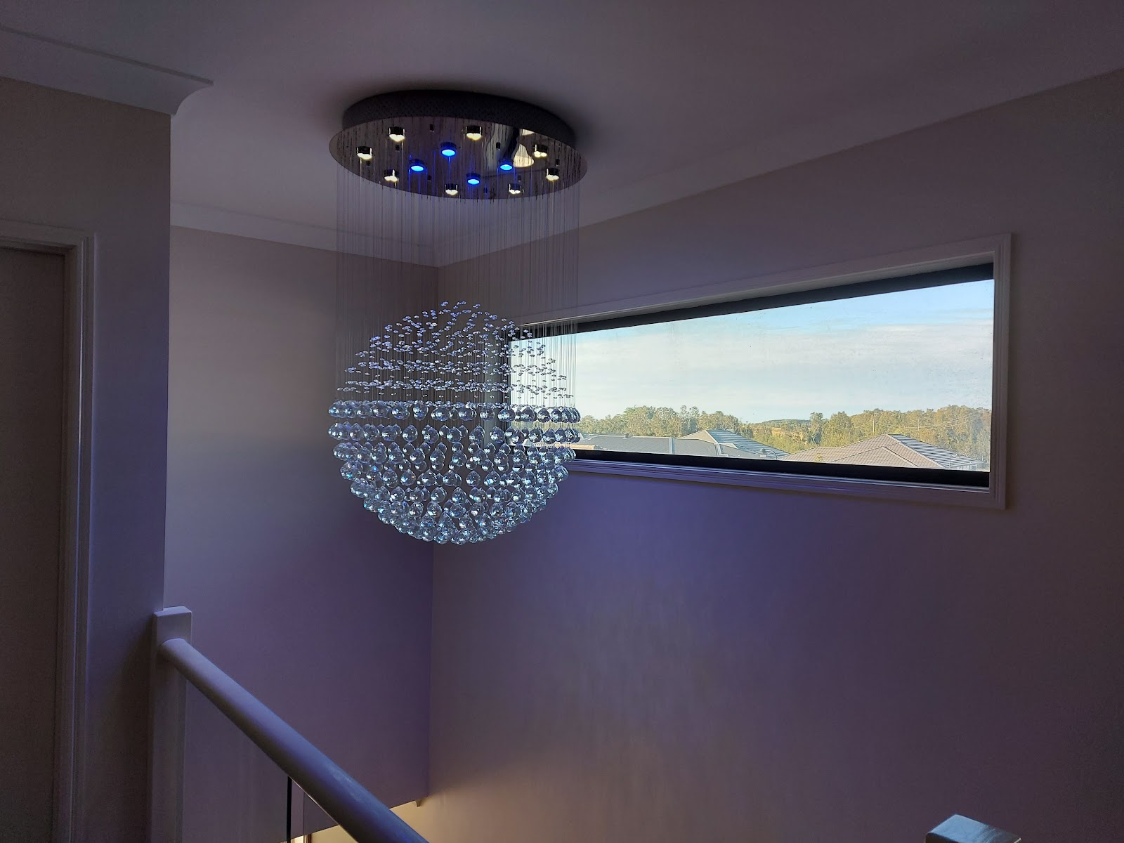 A crystal sphere pendant light installed in a stair void