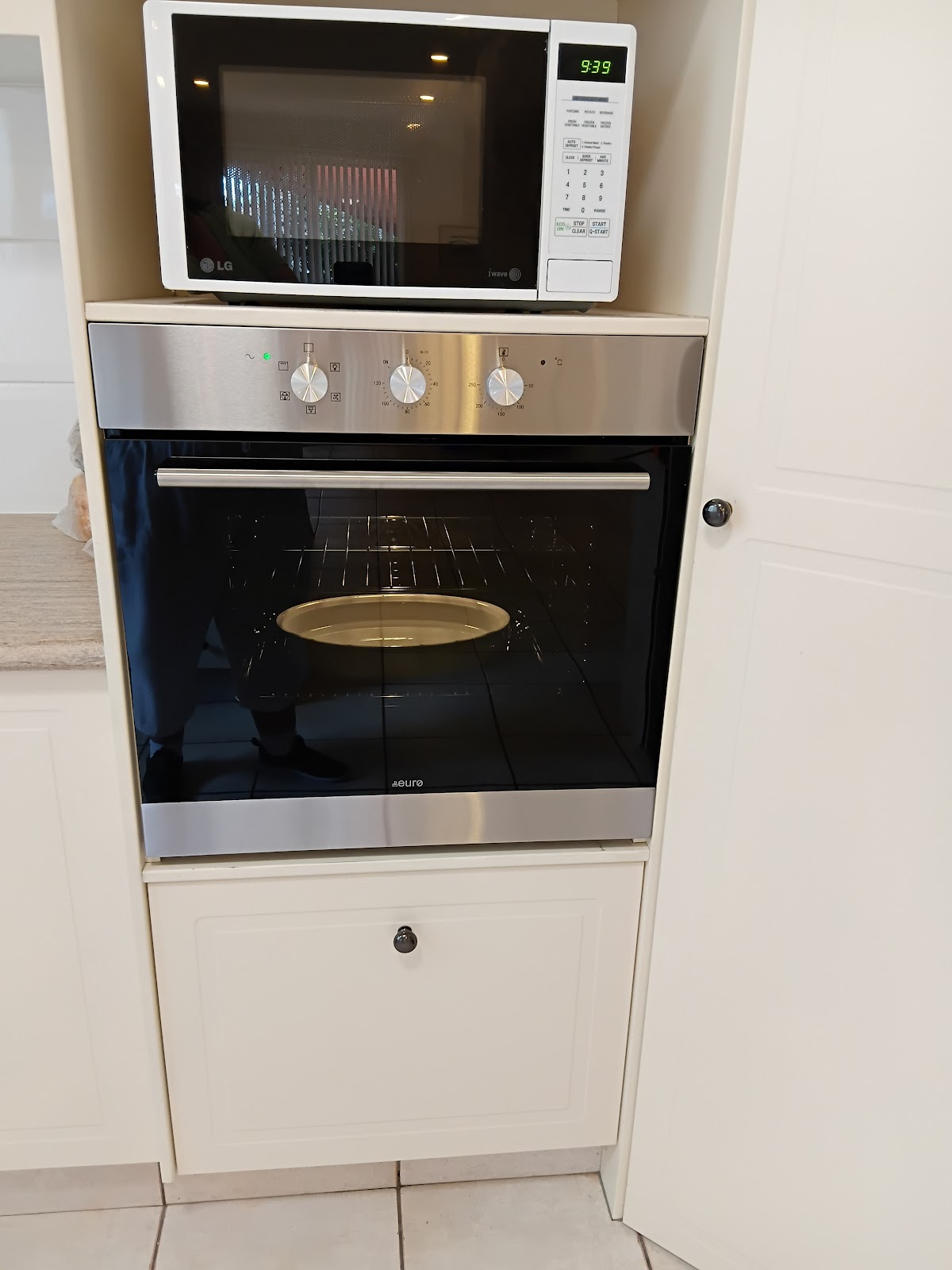 Wall oven installed under a microwave, switched on